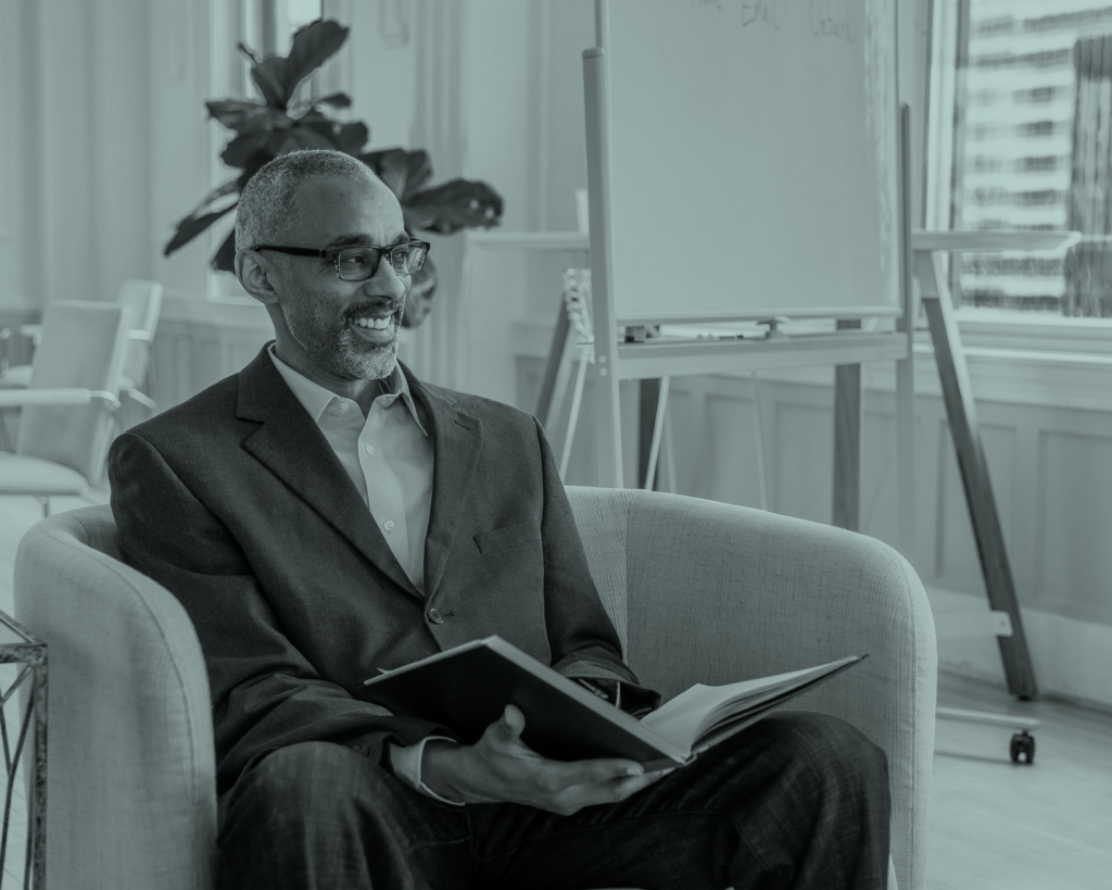 Man sitting in chair with a notebook