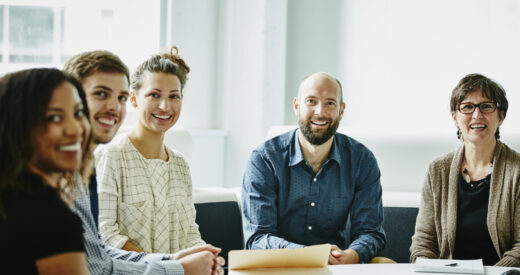 Smiling group of businesspeople in team meeting in office conference room