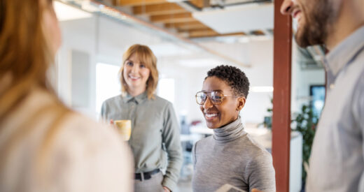 Group of multi-ethnic business team having a standing meeting in office. Business people talking during a break in office.