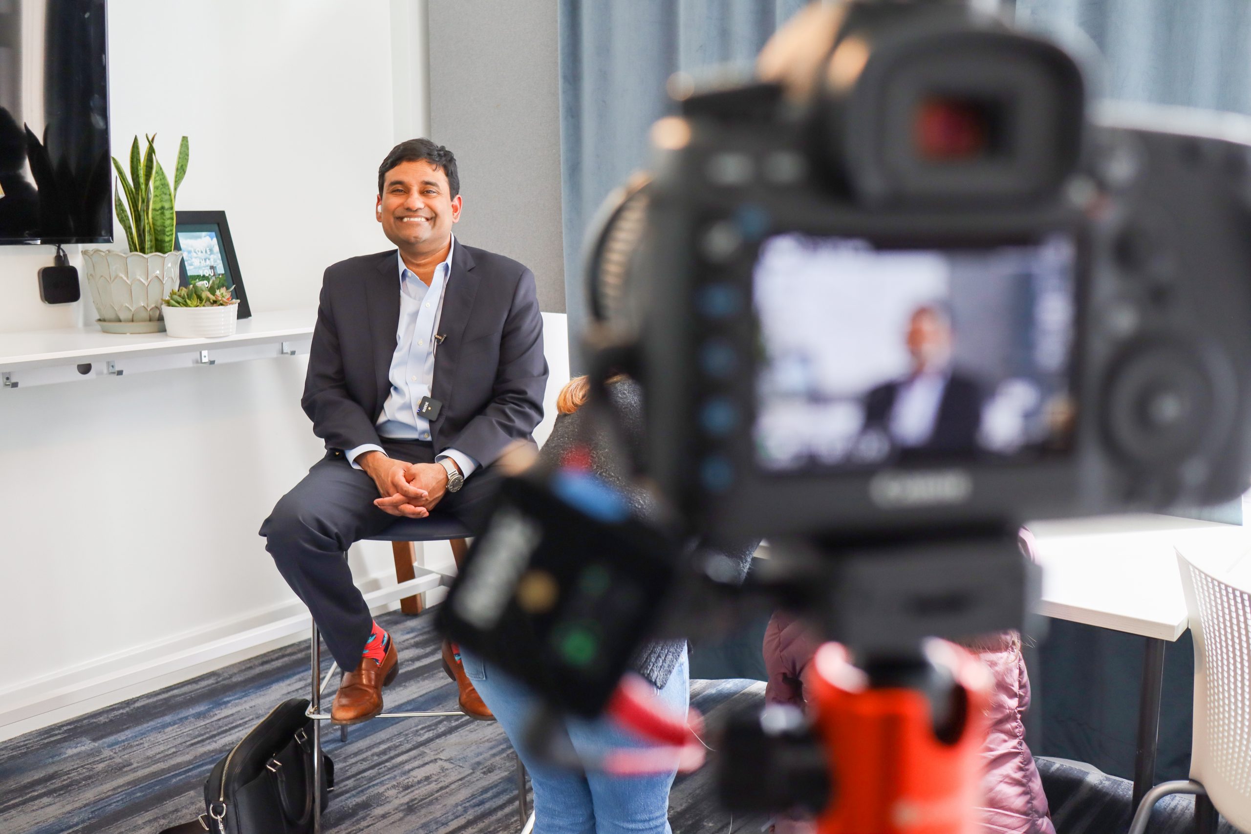 John Samuel smiling in front of a camera