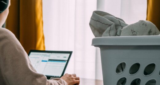 woman working from home and doing laundry beside her