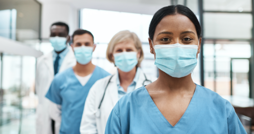 Portrait of a group of medical practitioners wearing face masks while standing together in a hospital