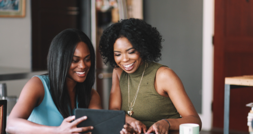 two Black women looking at a tablet