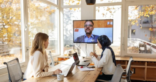 two employees in office on a zoom call with a remote employee