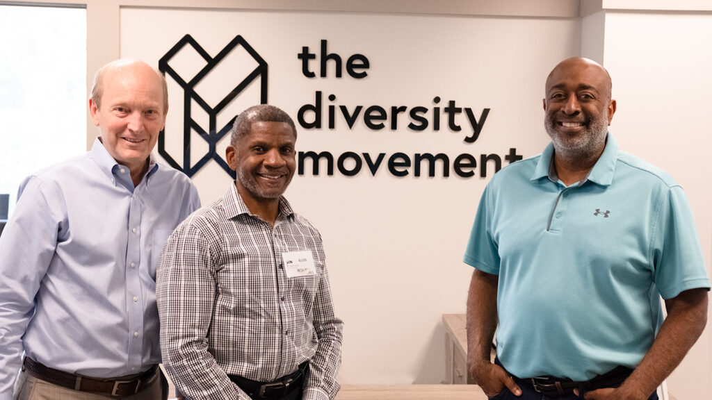 Donald, Tom, and Keith standing in front of a TDM sign