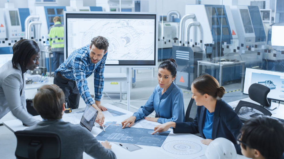 Modern Factory Office Meeting Room: Busy Diverse Team of Engineers, Managers and Investors Talking at Conference Table, Use Interactive TV, Analyze, Find Solutions, Debate and Discuss Engine Concept