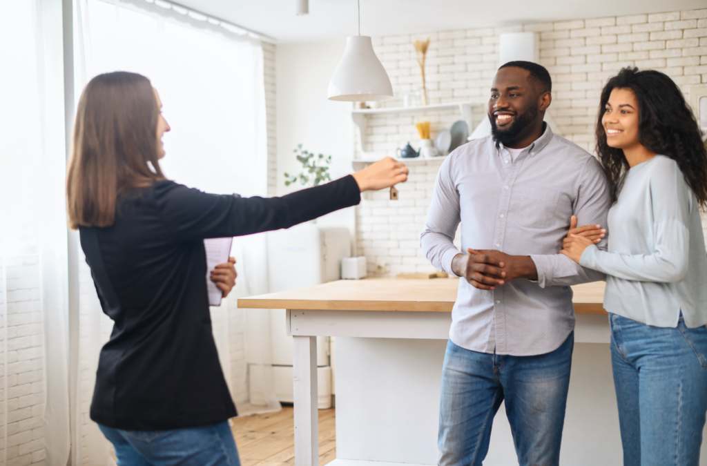 A smiling multiracial couple receives the keys to a new home from a real estate agent, smiling Black man and woman rent new apartment