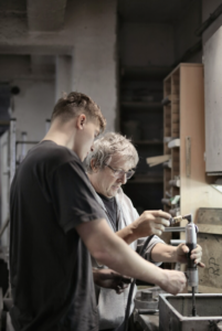 young man assisting an older woman at work