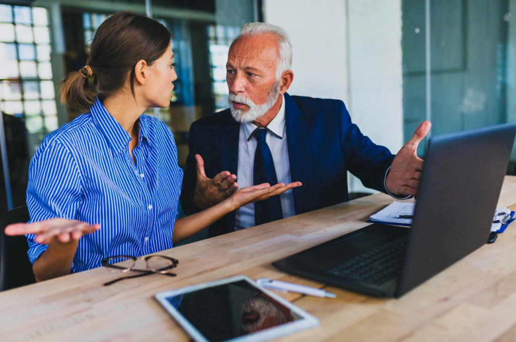 Older manager criticizing younger employee