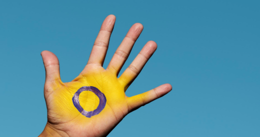 The intersex flag in the palm of the hand stock photo
