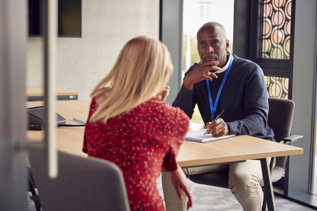 Female University Or College Student Having Individual Meeting With Tutor Or Counsellor