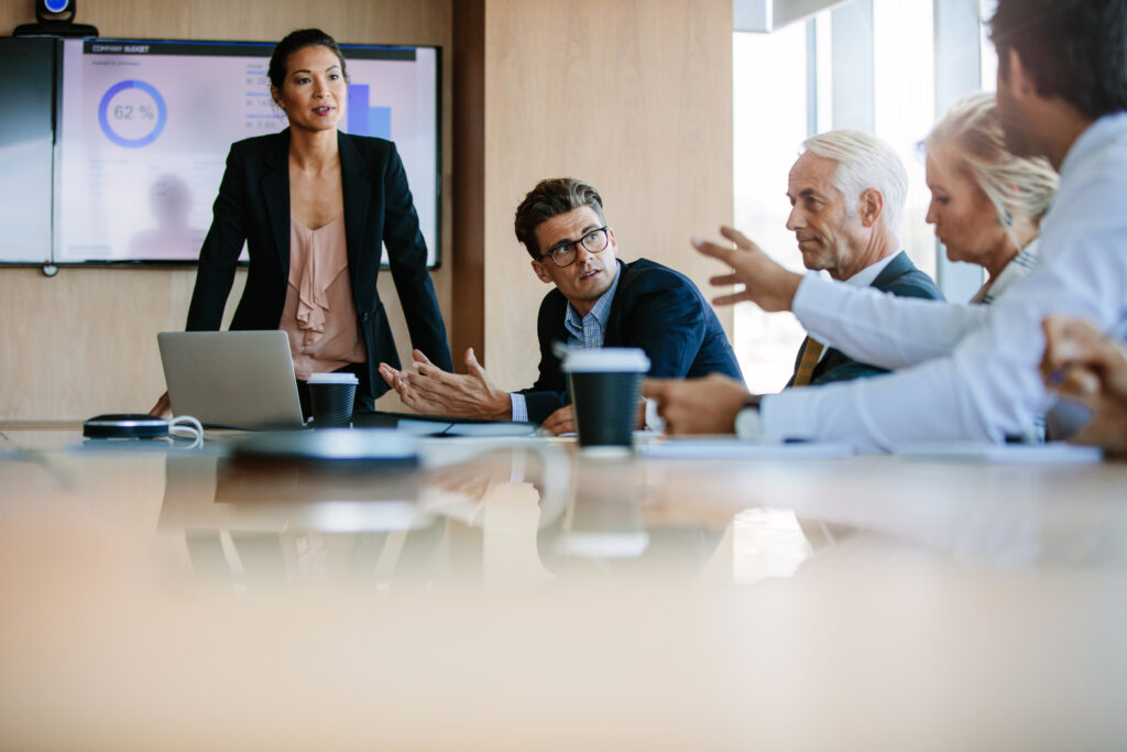 Team of business people sitting together in discussion around conference table. Diverse business group having a meeting in boardroom.