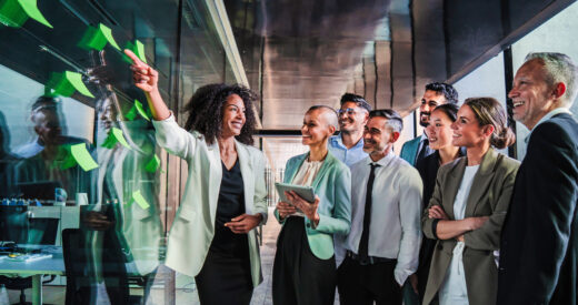 Group of business people start up team work brainstorming using post it in the office on a happy collaboration meeting. Businesswoman explaining the new marketing strategy or plan to her coworkers. High quality photo