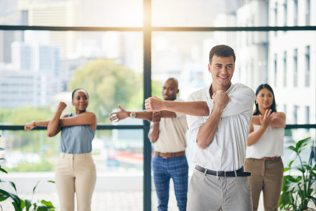 Workout, stretching and a group of business people in the office to exercise for health or mobility together. Fitness, wellness and coach training an employee team in the workplace for a warm up