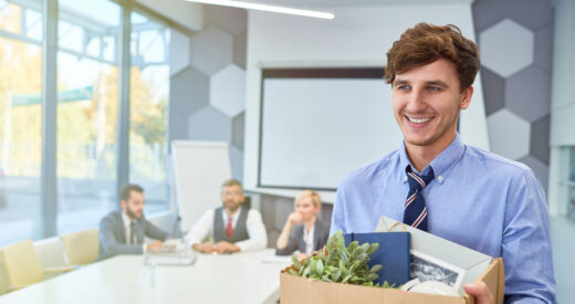 Portrait of smiling young man holding box of personal belongings being hired to work in business company, copy space