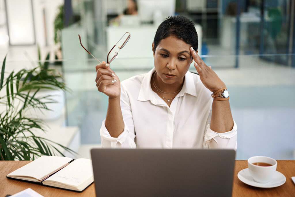 Shot of a mature businesswoman looking stressed out while working on a laptop in an office