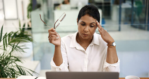 Shot of a mature businesswoman looking stressed out while working on a laptop in an office