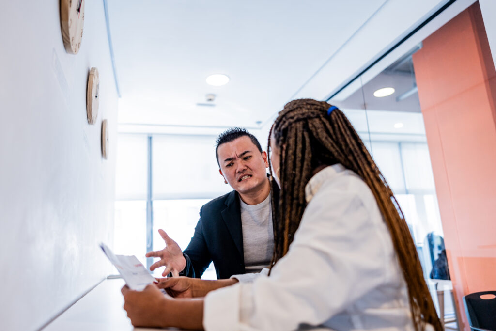 Mid adult leader man complaining to employee at office