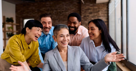 A diverse business team celebrates success in a modern office.